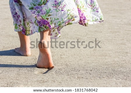 Beautiful foot footprints in the sand killing on nature background
