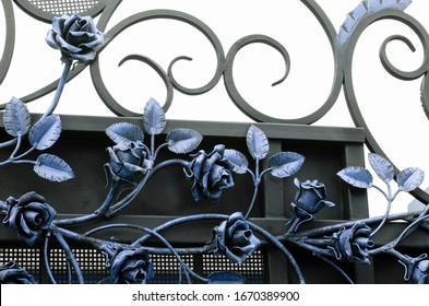 Beautiful Forged Roses In Cold Colors On A Metal Fence