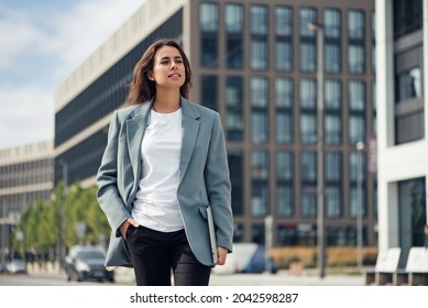 Beautiful Formal Dressed Business Woman In Suit With A Laptop And Notebook Outdoor. Brunette Caucasian Female, Standing Near Office.