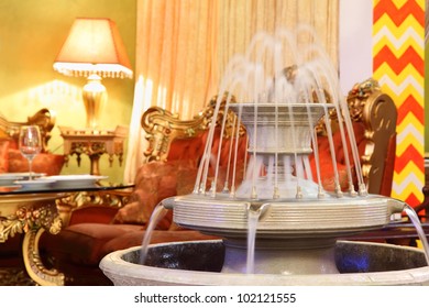 beautiful fountain in eastern luxury restaurant; carved red sofa