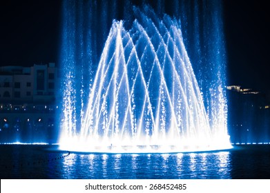 Beautiful fountain at night illuminated with blue light.