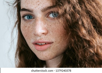 Beautiful Freckles young woman close up portrait. Attractive model with beautiful blue eyes and ginger curly hair  - Powered by Shutterstock