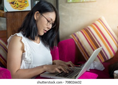 beautiful freelance businesswoman working on her laptop while sitting at the sofa - Shutterstock ID 708026632
