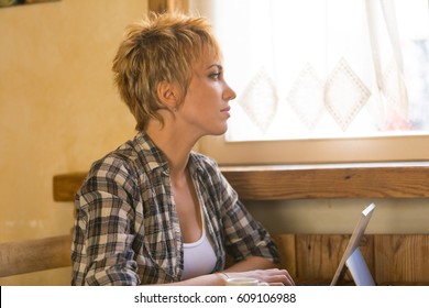 beautiful freelance woman working on her laptop in a rustic cafeteria - Shutterstock ID 609106988