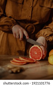 Beautiful fresh fruit carefully placed on a wooden surface while  being cut by a woman and placed on a glass fruit tray - Shutterstock ID 1921101776