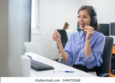 Beautiful Friendly Female Costumer Service Operator Showing Thumb Up To Computer Screen During Video Call In Call Centre