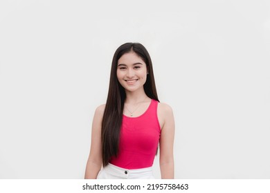 A Beautiful And Friendly Female Freshman College Student In A Pink Sleeveless Blouse Smiling. Isolated On A White Background.