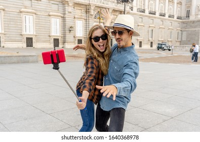 Beautiful friends tourist couple in love taking selfies at sunset while walking and visiting an European city outdoors in a romantic vacation. In Tourism, travel destination and vacation concept.