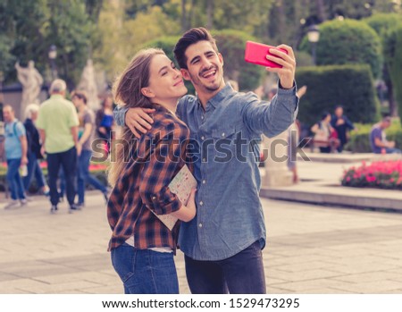 Similar – couple taking selfie in the street