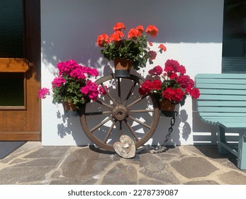 Beautiful front door with flowers in Austria. Decorations made from wagon wheels and pelargonium - Powered by Shutterstock