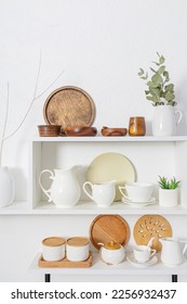 Beautiful front vertical view of the white wooden open shelves with dishes made of eco-friendly materials. The concept of a clean house without waste. - Shutterstock ID 2256932437