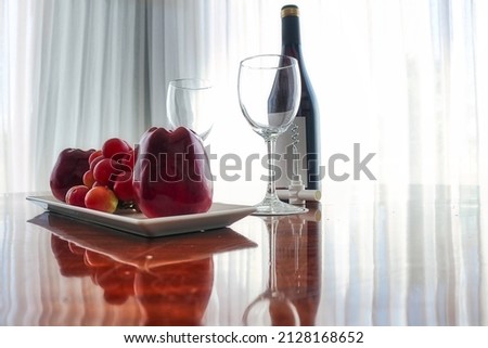 Beautiful fruit arrangement on a table, accompanying a bottle of wine