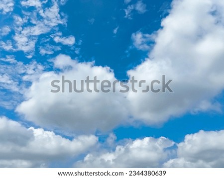 Beautiful full clouds on blue sky background. Elegant rainy white clouds in daylight. Big soft white fluffy clouds covered the blue sky. Cumulus clouds against deep blue sky. Sunny day. No focus
