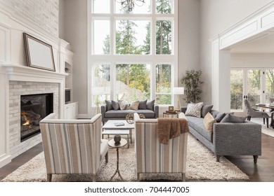 Beautiful Furnished Living Room Interior With Fireplace In New Luxury Home. Large Bank Of Windows Allows For Plenty Of Natural Light. Includes View Of Eating Nook. 