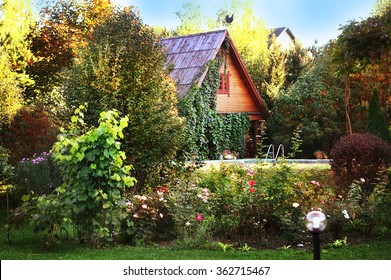 Beautiful Garden With Cottage House On The Background