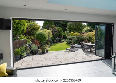 Beautiful garden and patio in summer seen from stylish designer room through bifold doors.
 - Shutterstock ID 2236356769