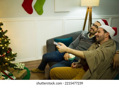 Beautiful Gay Couple Wrapped In A Blanket Having A Relaxing Christmas Night Looking Holiday Movies In The Living Room 