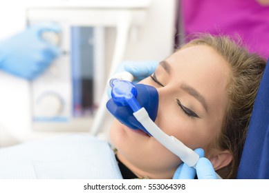 Beautiful getting woman inhalation sedation at dental clinic - Shutterstock ID 553064398