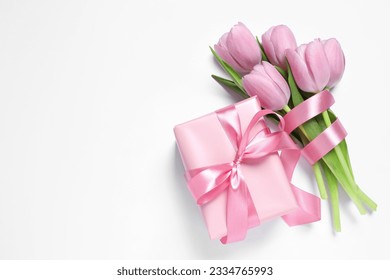 Beautiful gift box with pink bow and tulips on white background, flat lay. Space for text - Powered by Shutterstock