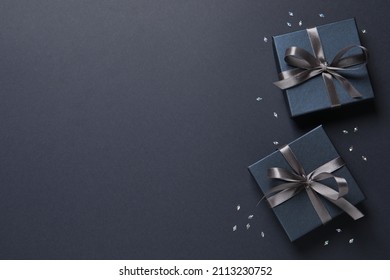 Beautiful gift boxes and confetti on black background, flat lay. Space for text - Powered by Shutterstock