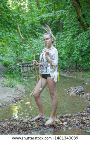beautiful girl with american indian feathers holds bow and arrow