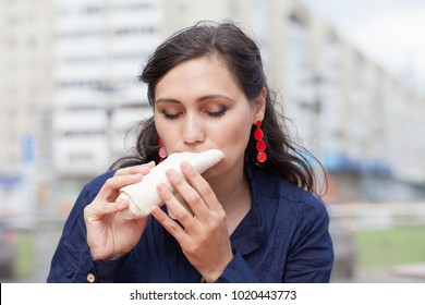 Beautiful Girl With An Appetite Eating A Burrito On The Street