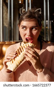 Beautiful Girl With An Appetite Eating A Burrito In The Cafe