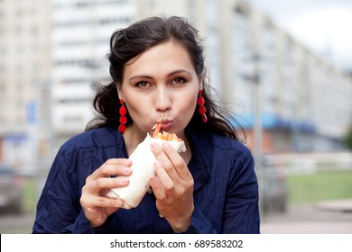 Beautiful Girl With An Appetite Eating A Burrito On The Street