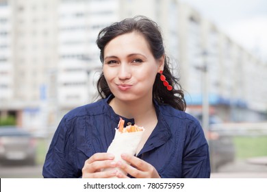 Beautiful Girl With An Appetite Eating A Burrito On The Street