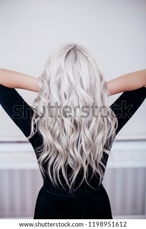 beautiful girl back with silver grey ash blonde curly wavy long hair in black dress isolated Stock photo © 