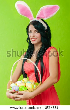 Beautiful girl with a basket of Easter eggs in a bunny suit