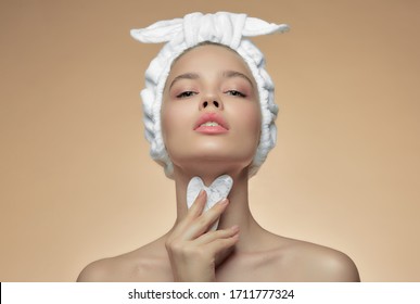 Beautiful girl with beauty gua Sha quartz stone for massage. The beige background is isolated. Cosmetic natural trend.