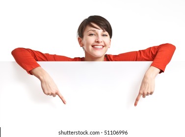 beautiful girl behind empty board smiling and pointing her fingers down