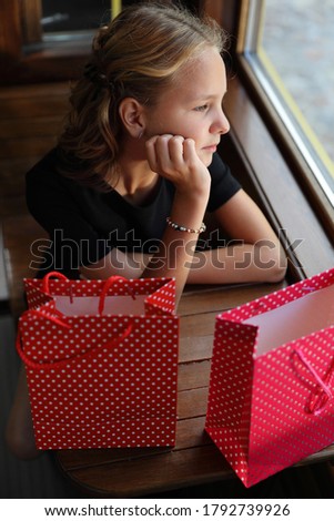 beautiful girl in a black dress sits on a tram with purchases