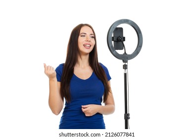 The Beautiful Girl Blogger Communicates With The Subscribers Of Her Channel Using A Smartphone And A Ring Light. Isolated On A White Background.