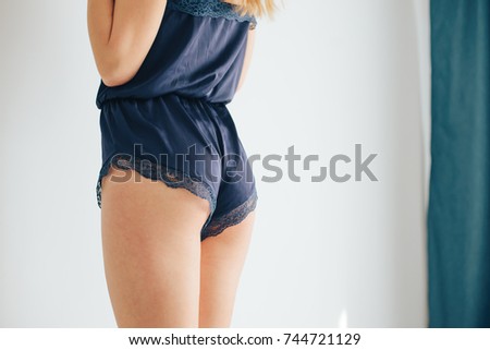 Beautiful girl blonde at home, shorts and t-shirt, pajamas posing in the interior of the house