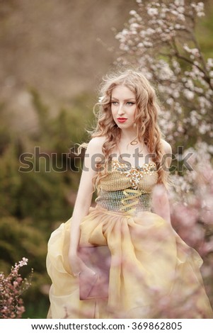 Beautiful girl in blooming spring garden