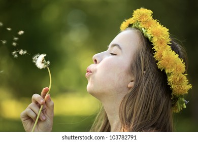 	Beautiful girl blowing dandelion