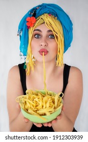 A Beautiful Girl With Blue Eyes Is Eating Pasta. Woman Is Holding Spagetti Plate. Hungry Girl Is Enjoying Macaroni.