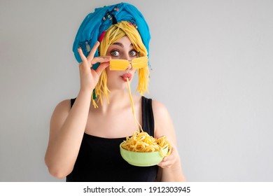 A Beautiful Girl With Blue Eyes Is Eating Pasta. Woman Is Holding Spagetti Plate. Hungry Girl Is Enjoying Macaroni.