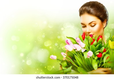 Beautiful girl with a Bouquet of colorful Tulip flowers. Beauty Woman with Spring Flower bunch. Happy surprised model woman smelling flowers. Mother's Day gift. Valentine's Day. Springtime