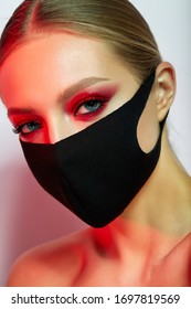 Beautiful Girl With Bright Creative Make-up. Young Model In A Black Mask On Her Face. Coronavirus Protection. Beauty Face. Photo Taken In The Studio.