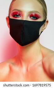 Beautiful Girl With Bright Creative Make-up. Young Model In A Black Mask On Her Face. Coronavirus Protection. Beauty Face. Photo Taken In The Studio.