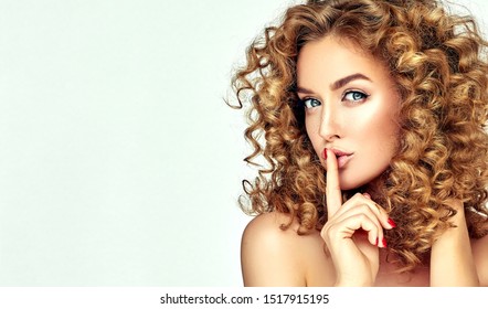 Beautiful girl with bright makeup and curly hair   telling a secret .Portrait  young happy woman who is calling to someone .Funny girl model  whispering about something. Expressive facial expressions