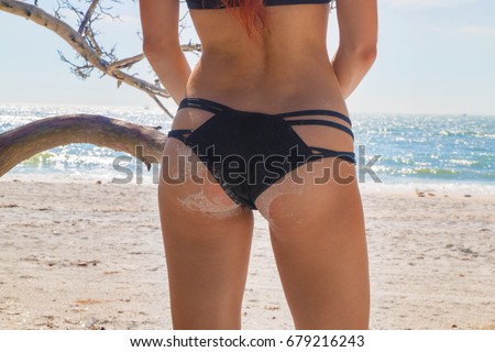 Beautiful girl butt in stylish bikini on tropical sandy beach