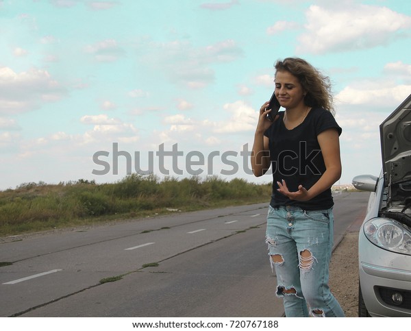 beautiful\
girl calls for help by phone, car\
breakdown