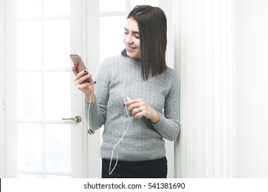 Beautiful Girl Chatting With Friends And Charges Her Phone. Powerbank And Smartphone In Girl's Hands. 