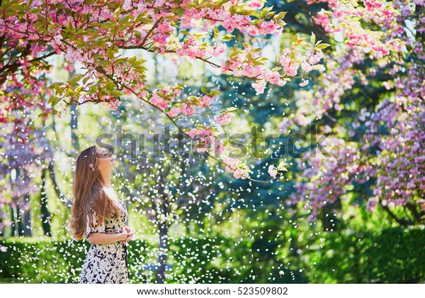春の日に桜の庭に咲く美しい少女 花の花びらが木から落ちる の写真素材 今すぐ編集