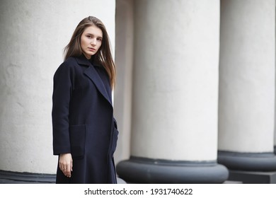 Beautiful girl in a coat in business downtown of the cloudy