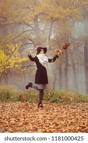 A Beautiful Girl In A Coat And Hat Walks On The Autumn Forest